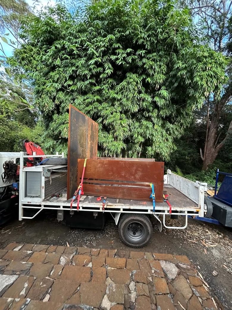 Fabricated COR-TEN steel panels strapped to the tray of the truck for delivery.